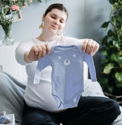 mãe olhando os tamanhos de roupas para bebê