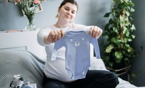 mãe olhando os tamanhos de roupas para bebê