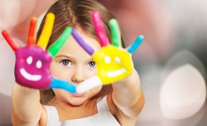 menina mostrando as mãos pintadas com diferentes cores